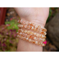 Citrine 8 inch 6mm beaded bracelet with delicate translucent orange and white gemstones featuring subtle red inclusions
