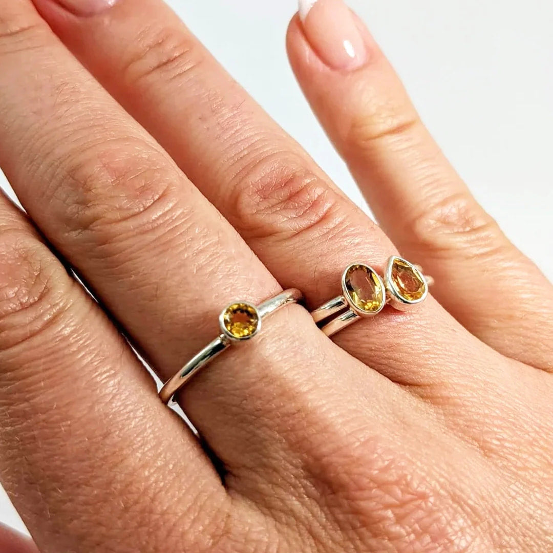 A woman’s hand with a Citrine Faceted Sterling Silver Ring in dainty stacking style