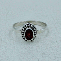 Oval faceted garnet sterling silver ring with bezel and beaded detailing