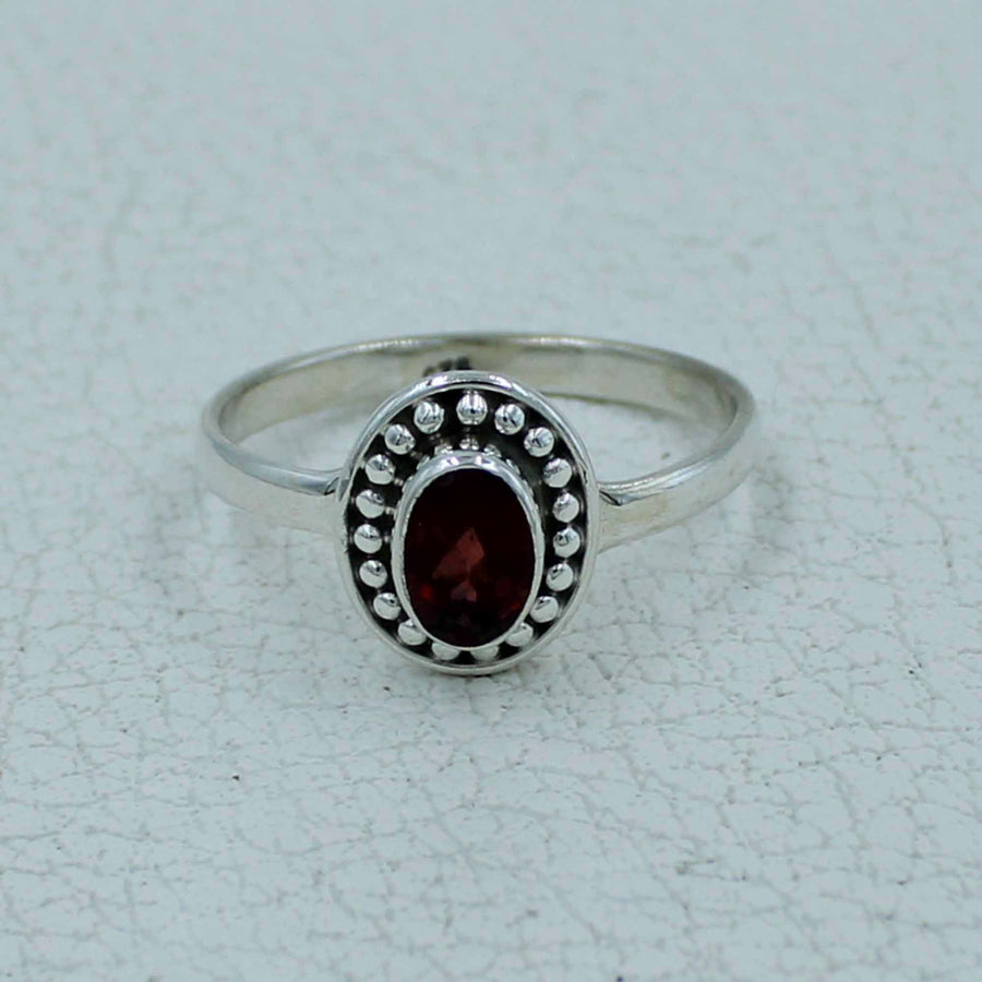 Oval faceted garnet sterling silver ring with bezel and beaded detailing