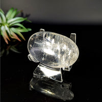 Clear crystal pig figurine displayed in Clear Optical Calcite 2.2 inch Palm Stone #LV8836
