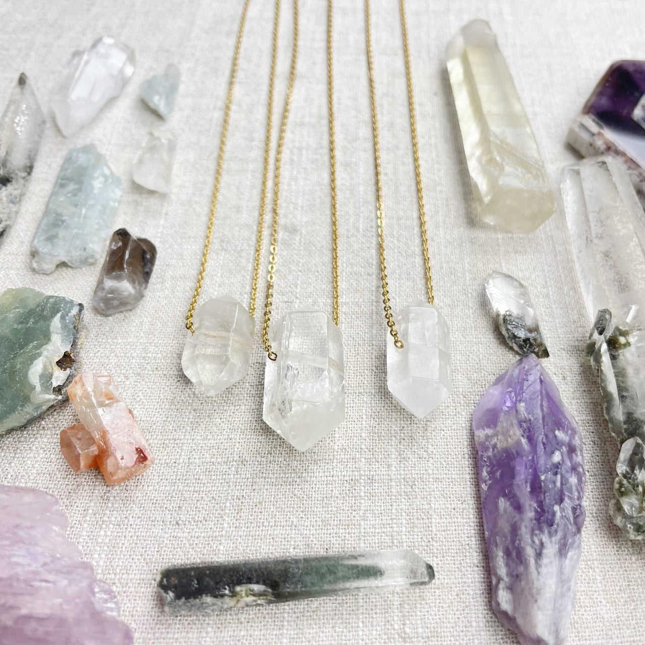 Three delicate 18’’ gold chain necklaces with faceted clear quartz pendants