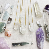 Three delicate 18’’ gold chain necklaces with faceted clear quartz pendants