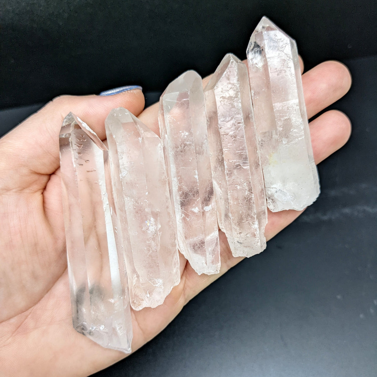 A hand holds a Clear Quartz Rough Point (48g) #SK1357, showcasing raw crystal beauty