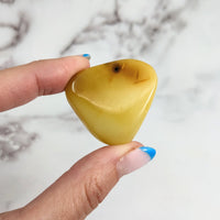 Thumbnail for Hand holding a yellow heart-shaped candle - Colombian Amber 1.5’ Polished Piece #LV3160