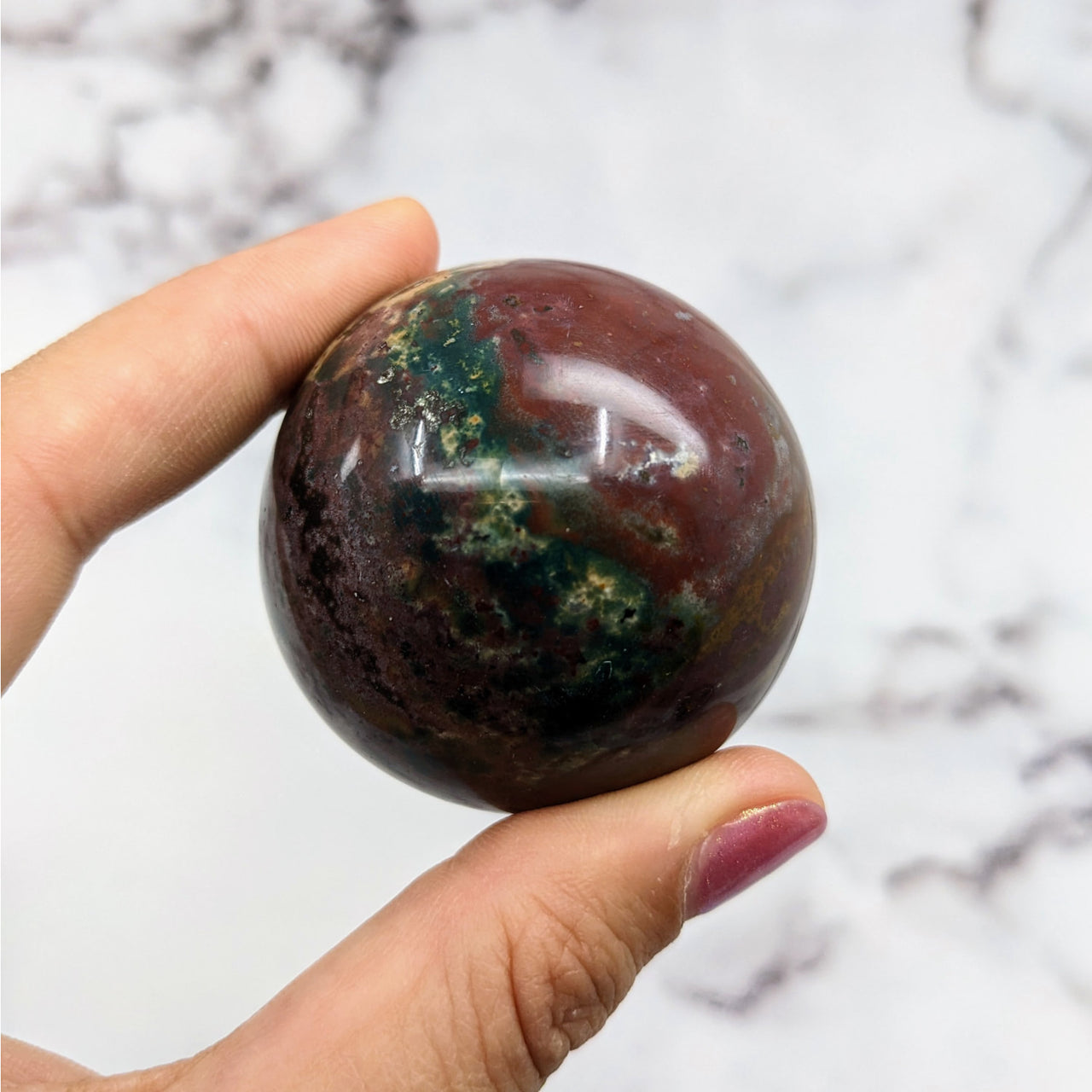 Hand holding Colorful Bloodstone Sphere #S062 — large green and black marble ball