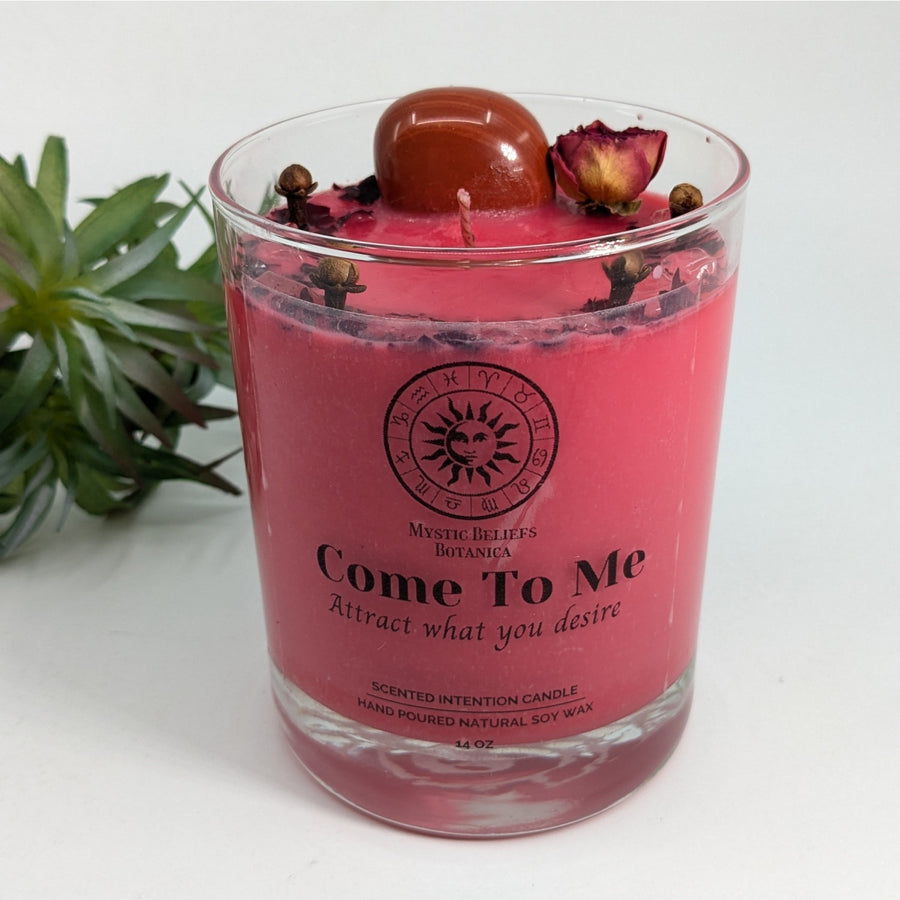 Pink candle in glass jar with Rose Quartz, red stone, and dried flowers for relaxation