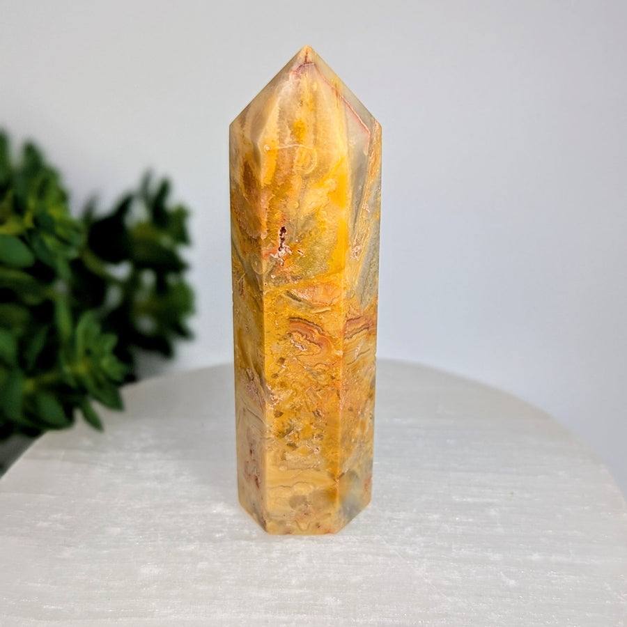 Crazy Lace Agate 3.33-inch yellow-orange tower with swirling patterns on white surface