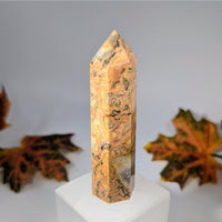 Yellow and brown marbled Crazy Lace Agate 3.5-inch tower on white pedestal