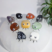 Collection of gemstone creatures with googly eyes and metal legs from Crystal Bug Pet Rock series