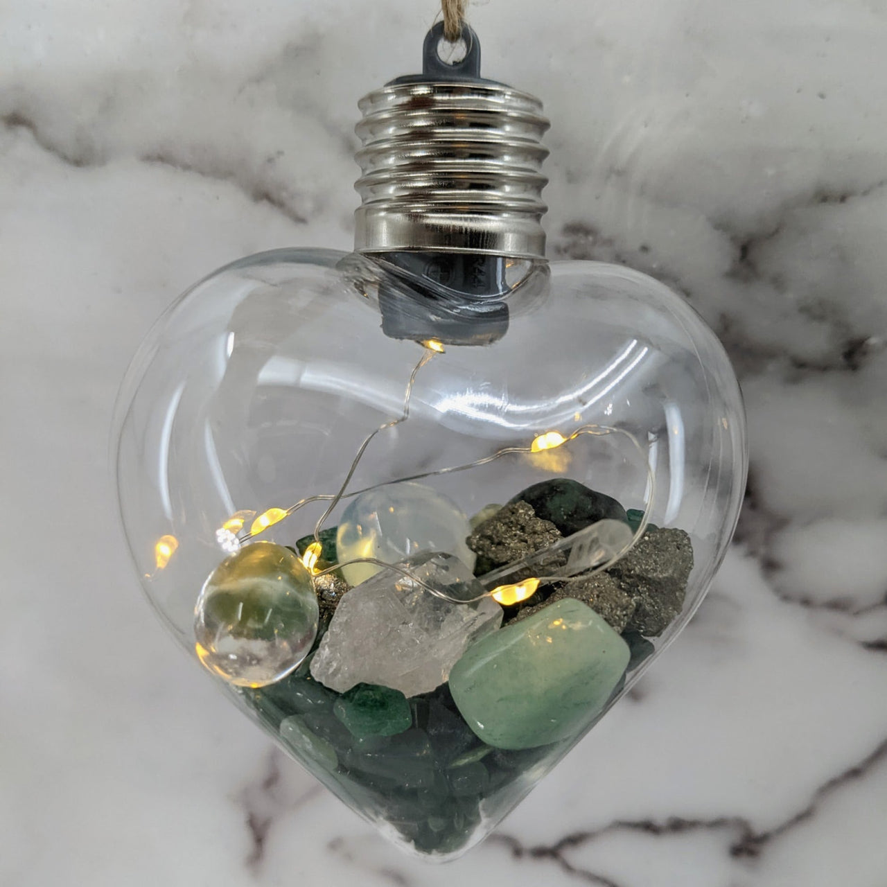 Heart-shaped glass light bulb filled with stones and fairy lights in Crystal Heart Ornament