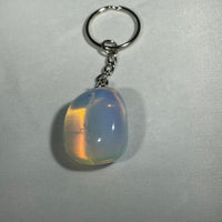 A smooth teardrop-shaped opal crystal keychain with a silver-toned metal ring and chain for everyday use