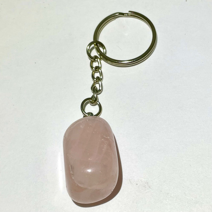 A smooth translucent pink rose quartz keychain with a metallic chain and ring for crystal keychain assorted q106