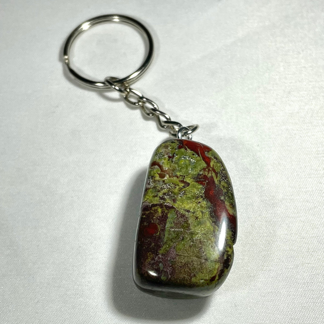 A polished green and red jasper crystal keychain with silver metal ring and chain for assorted use q106