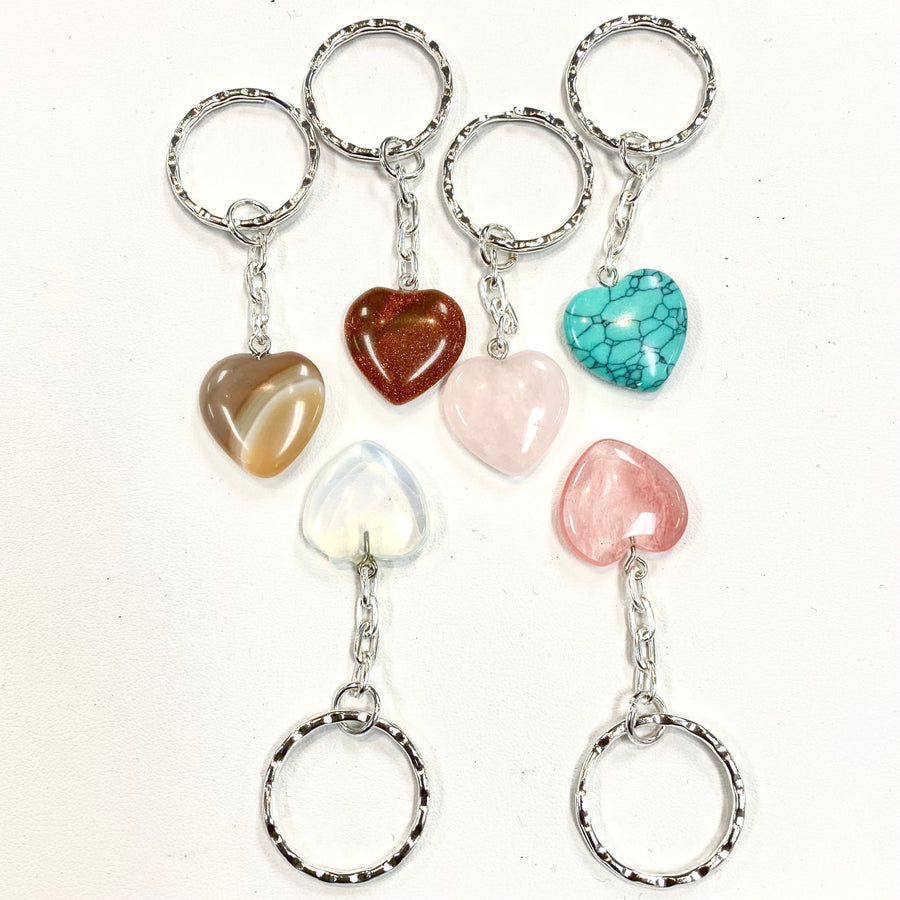 Set of six heart-shaped crystal keychains with polished gemstone pendants in assorted colors and silver chains