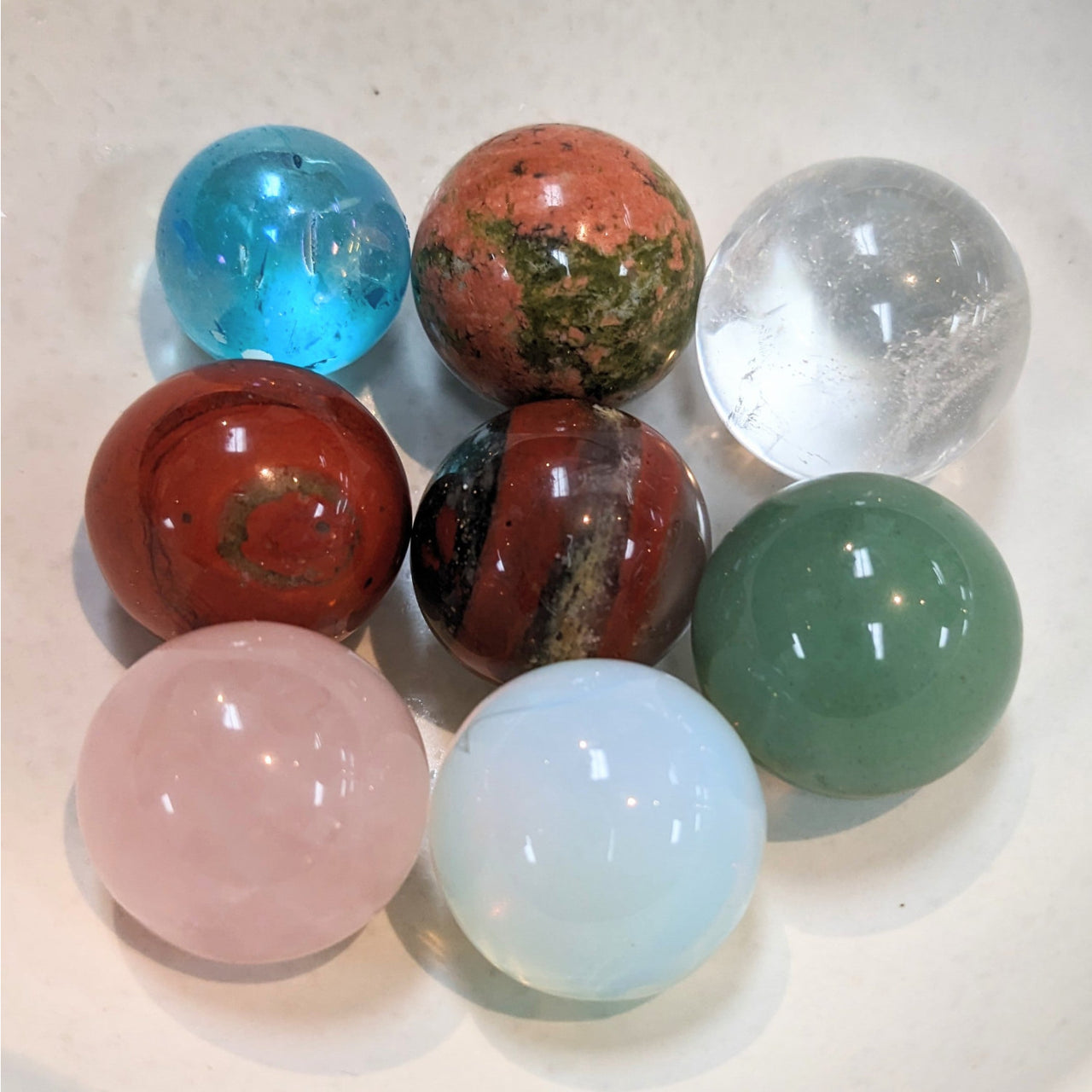 Colorful polished stone spheres, including rose quartz, in a cluster for Crystal Marble S015