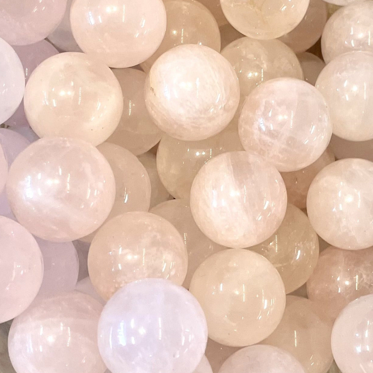 Smooth translucent rose quartz beads clustered together in Crystal Marble S015