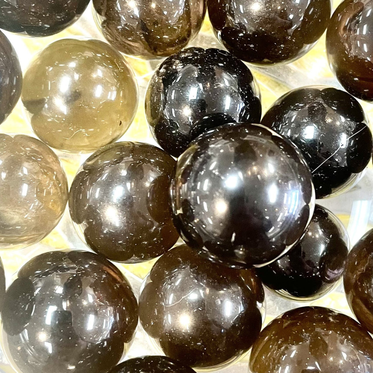 Polished dark smoky gray and translucent brown crystal marbles inspired by rose quartz