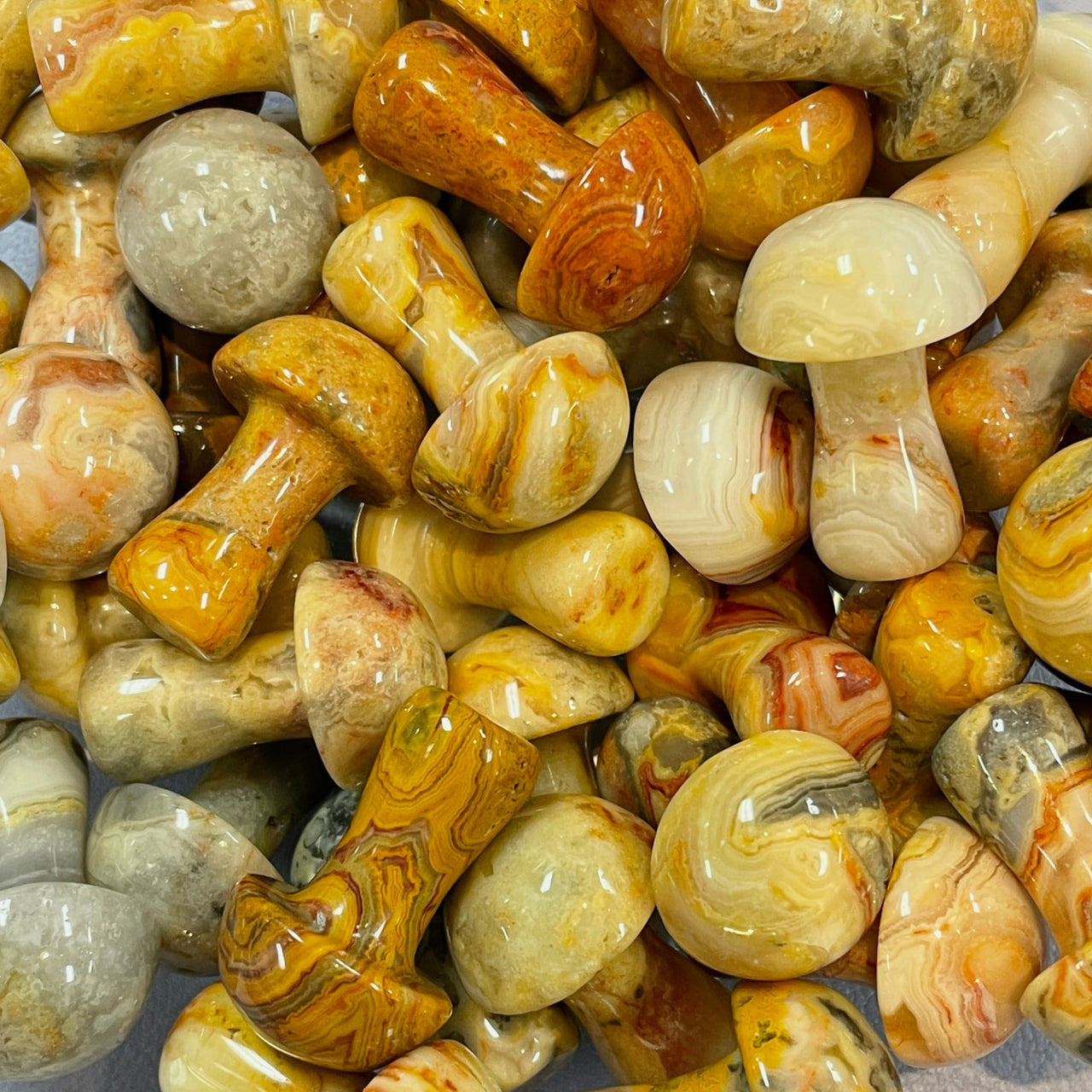 Polished yellow and cream agate stones with swirling patterns in Crystal Mushroom C041