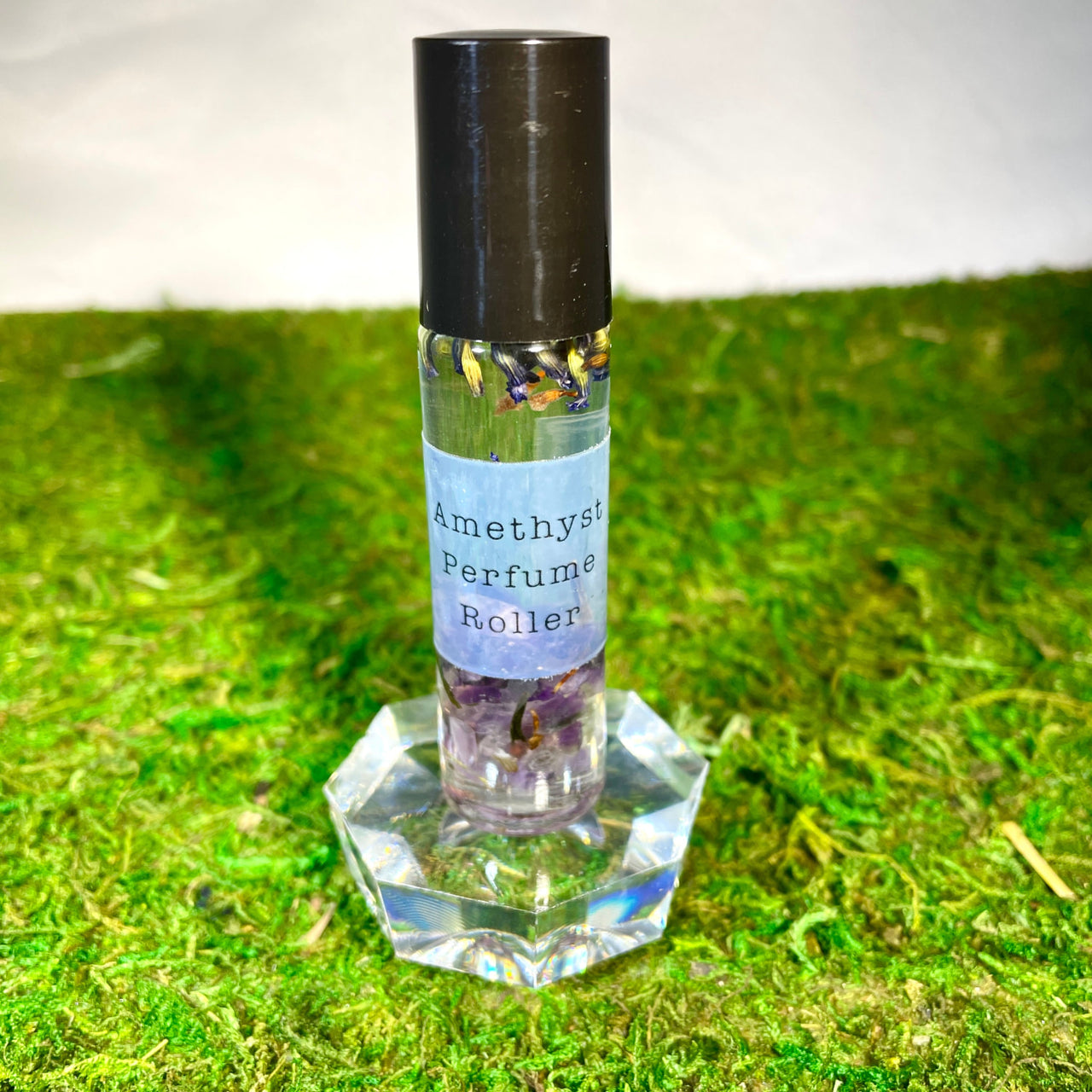 Crystal Perfume 10ml Roller #Q217 on green grass. Rejuvenating fragrance in nature