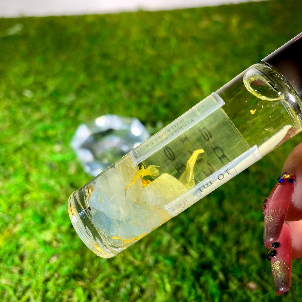 A person holding a Crystal Perfume 10ml Roller #Q217 in their hand