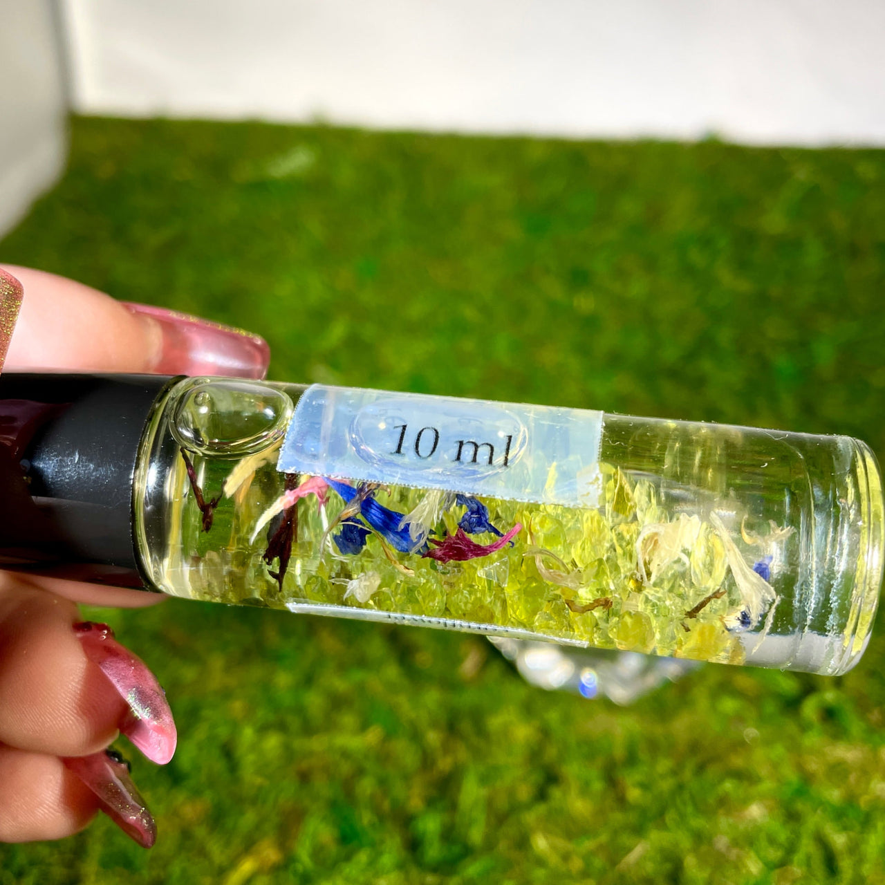 Crystal Perfume 10ml Roller #Q217 - a bottle of oil with a small flower inside