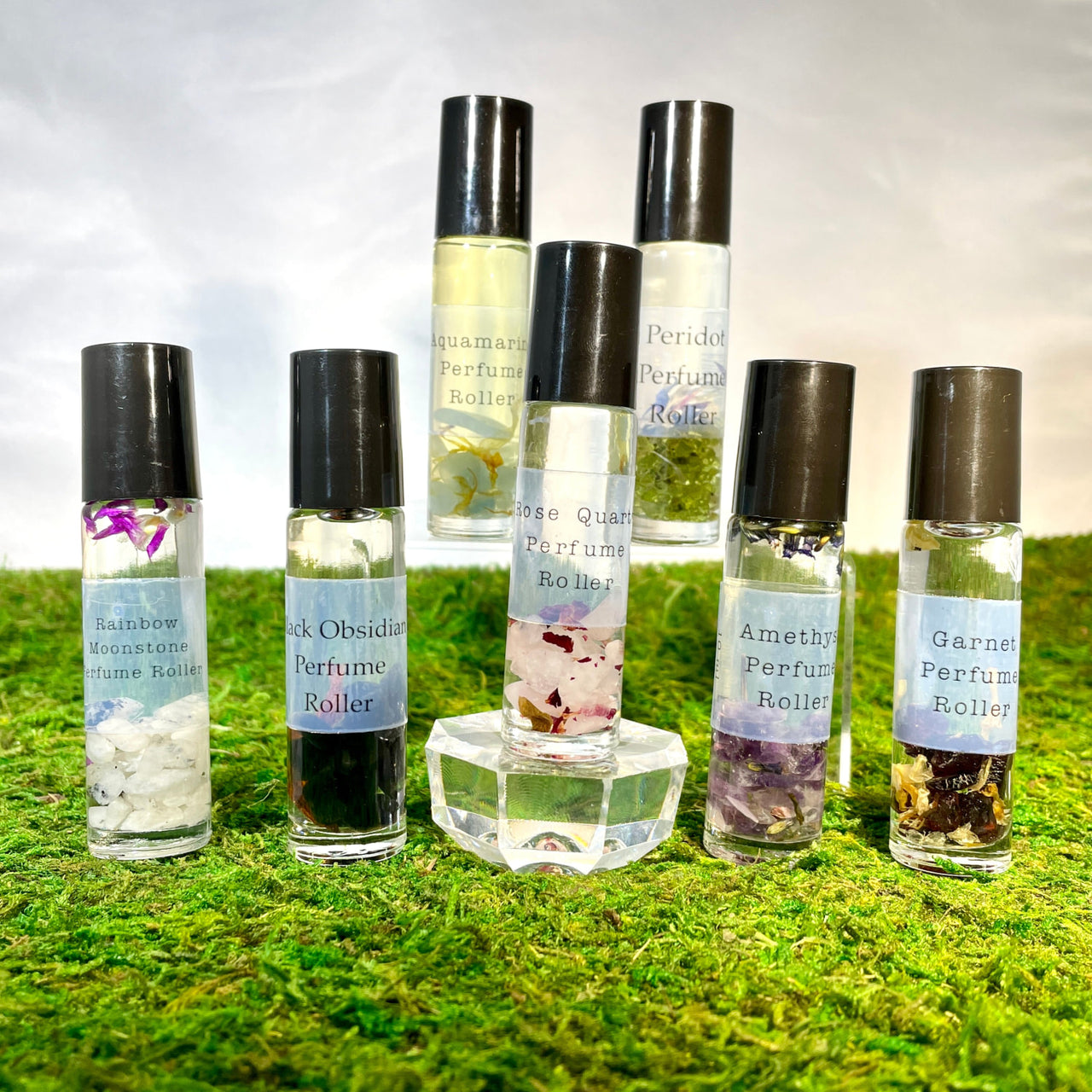 Crystal Perfume 10ml Roller #Q217 bottles on moss-covered ground in a natural setting