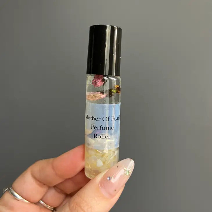 Hand holding Crystal Perfume 10ml Roller #Q217 with a flower inside the bottle