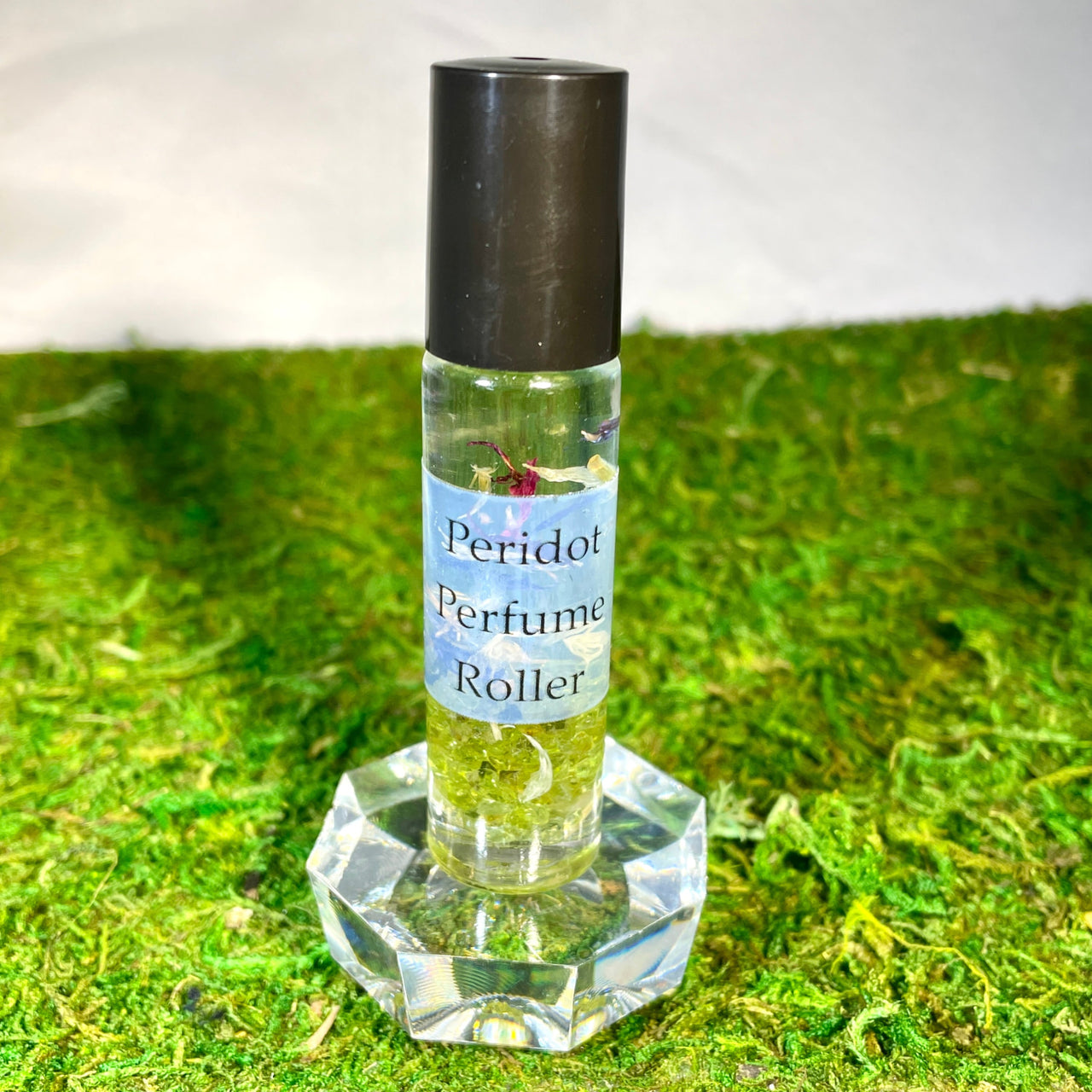 Crystal Perfume 10ml Roller #Q217 with black capped bottle and green moss backdrop