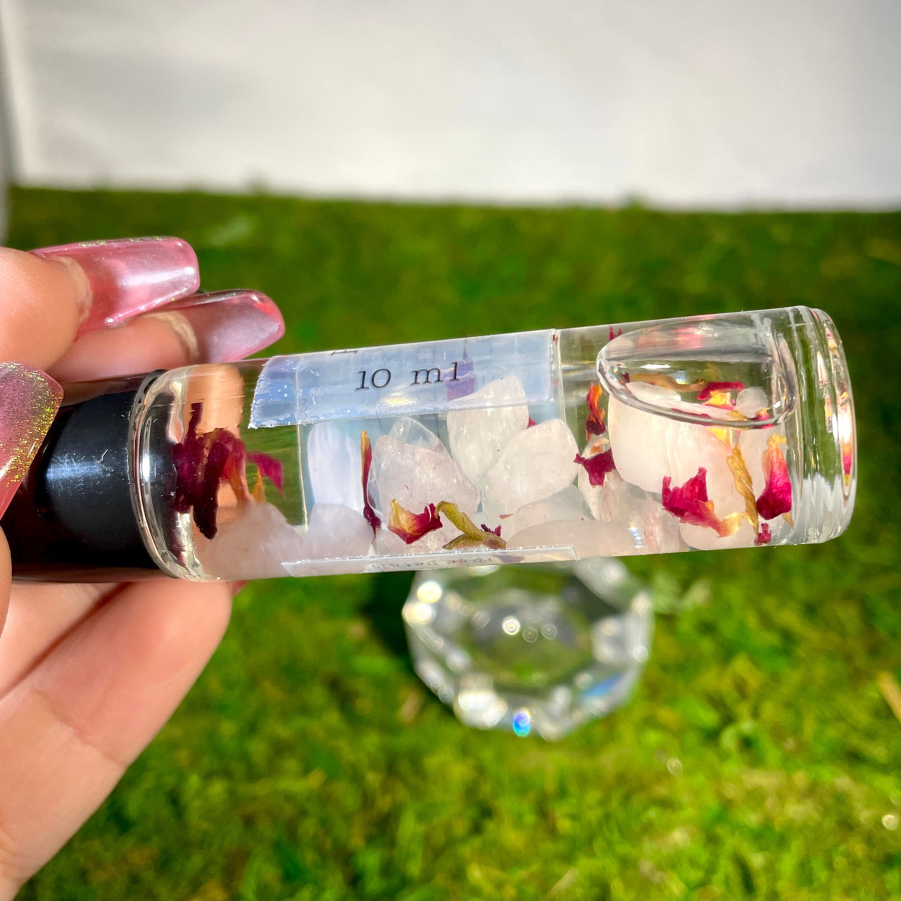 Person holding a floral-filled bottle of Crystal Perfume 10ml Roller #Q217