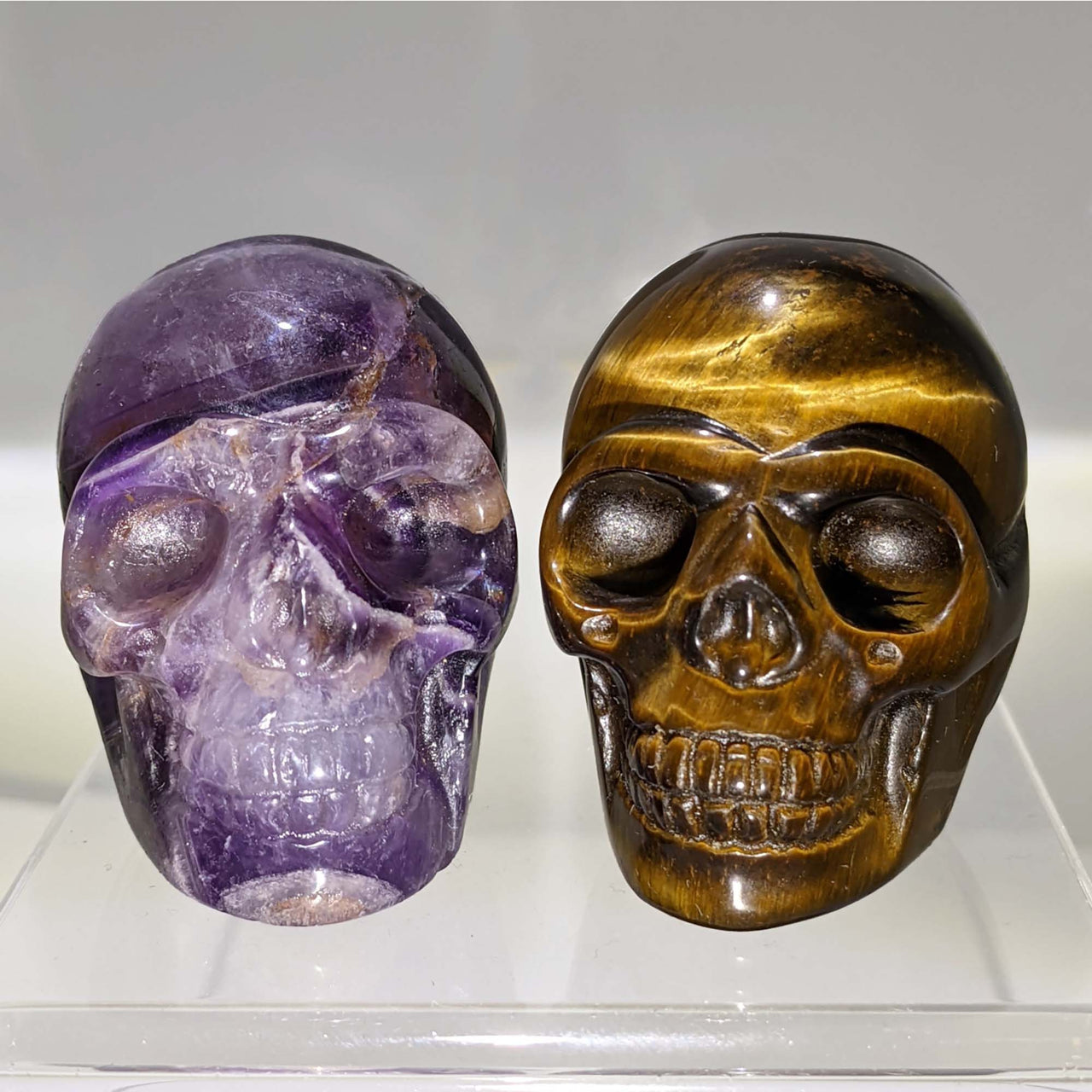 Two crystal skull carvings on display showcasing intricate details for collectors