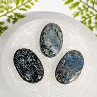 Dianite 1.5’’ mini palm stone #BC0927: three polished oval stones in gray, black, blue on white crystal dish