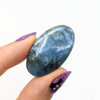 Thumbnail for Person holding Dianite Grade AA 1.4’ blue stone with purple glitter (#LV1237 Cabochon)