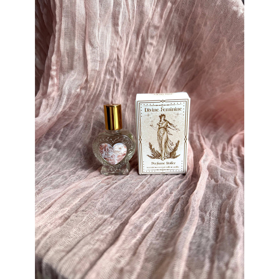 Heart-shaped Divine Feminine Coconut Vanilla perfume roller in glass bottle with gold cap and etched label, beside branded box, 15 ml #LV9591
