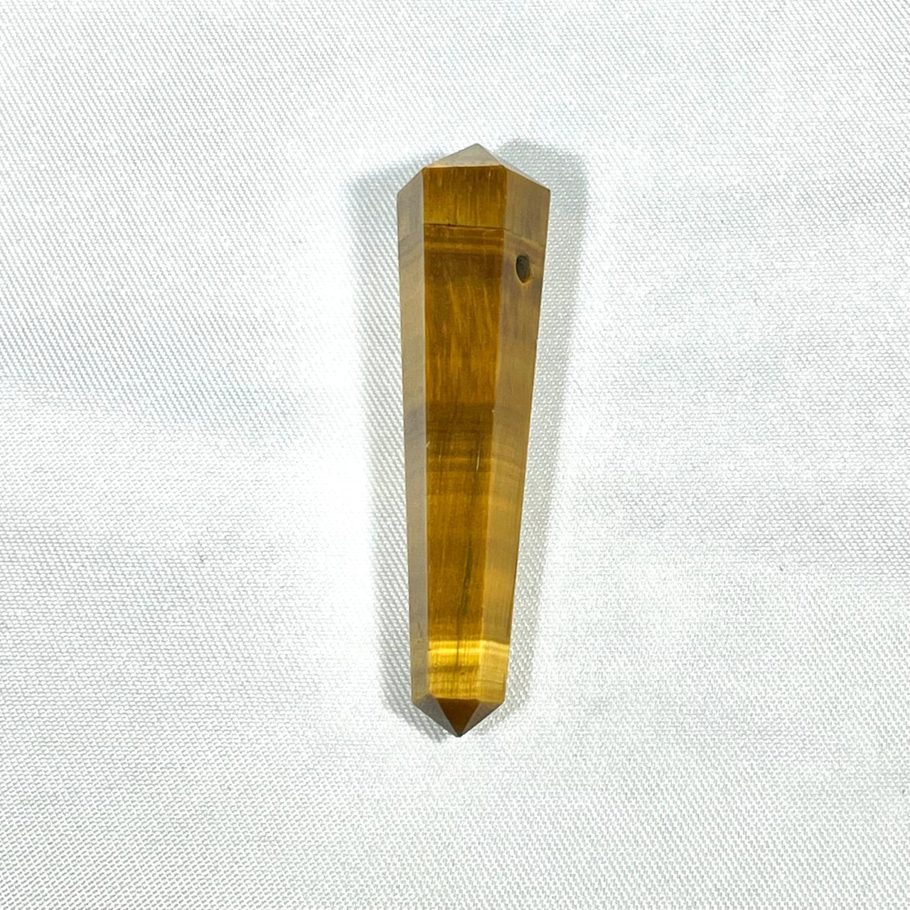 Elongated amber-colored double terminated crystal point pendant with hexagonal facets