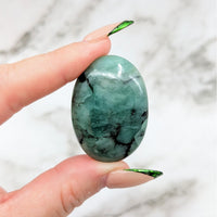 Thumbnail for A person holding an Emerald 1.5’ Palmstone #LV4565 green gem