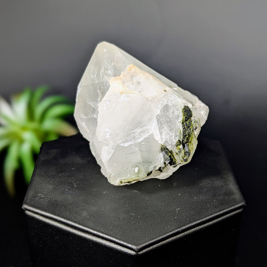 Translucent quartz crystal with green epidote inclusions in a natural point
