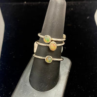 Thumbnail for Three delicate sterling silver rings with Ethiopian Opal gemstones on a ring holder