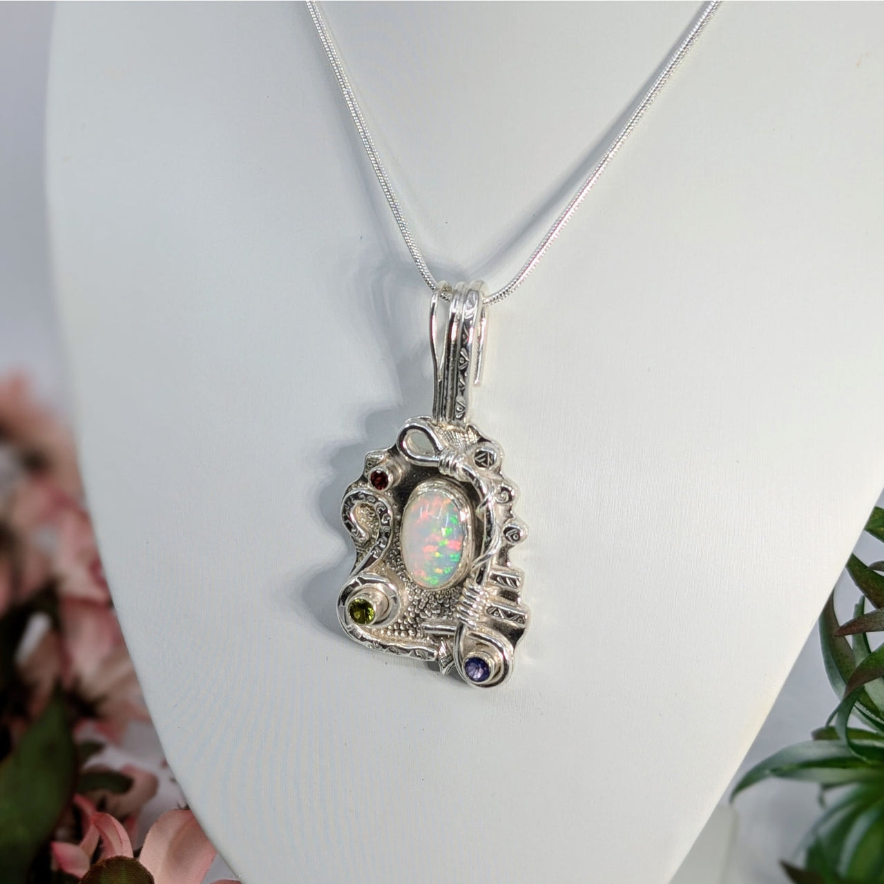 Ornate Ethiopian opal pendant with silver scrollwork and garnet, peridot, tanzanite accents