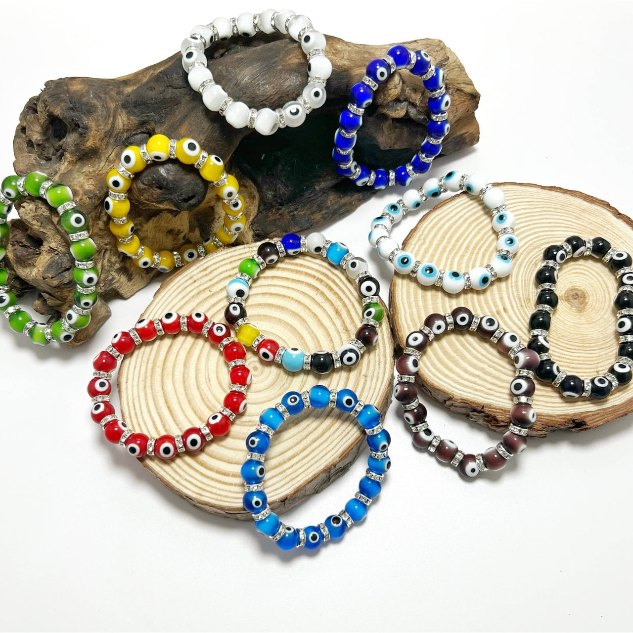 Multi-colored evil eye beaded bracelets on driftwood coasters LV9552