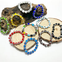 Multi-colored evil eye beaded bracelets on driftwood coasters LV9552