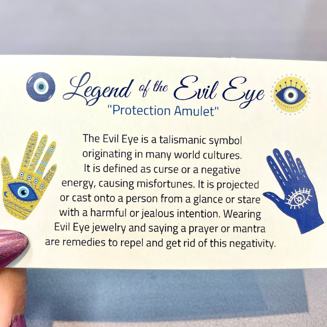A hand holding a card with ’Legend of the Eye’ from the EVIL EYE INFO CARD, Double Sided #HC376