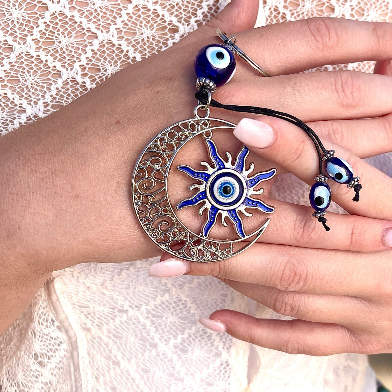 A woman wearing a bracelet with an evil eye, showcasing Evil Eye Keychain/Ornaments #Q198