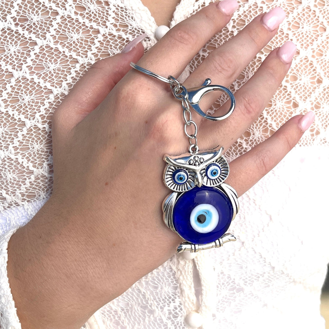 Woman wearing owl ring, Evil Eye Keychain/Ornaments #Q198 in the background