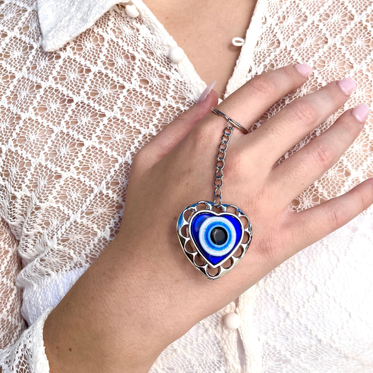 A woman wearing a bracelet with a blue eye from the Evil Eye Keychain/Ornaments collection