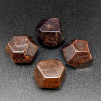 Thumbnail for Three brown quartz stones on display, showcasing the faceted red garnet polygon #SK8089