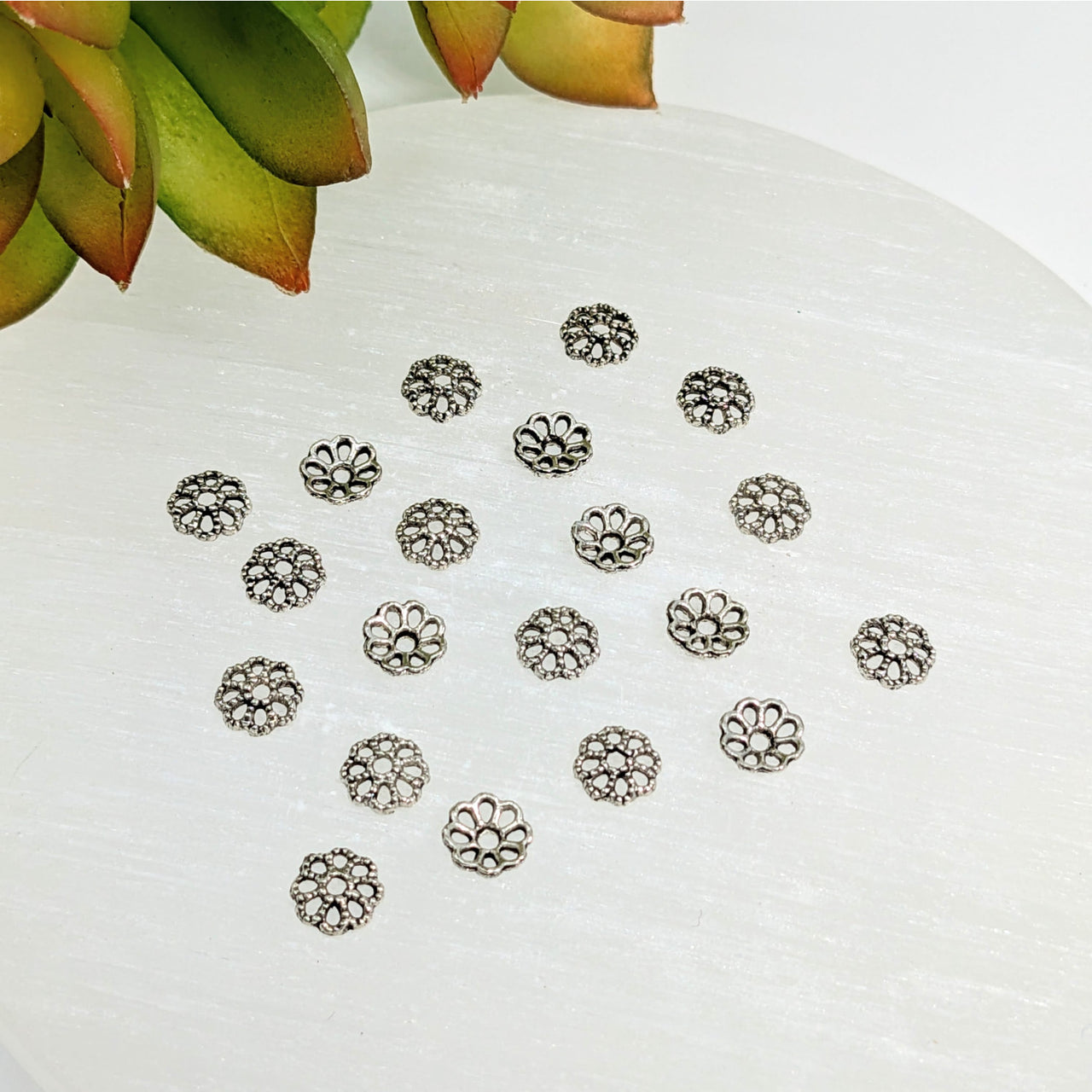 Silver-toned flower-shaped filigree bead caps 7mm small pewter scattered in a loose pattern