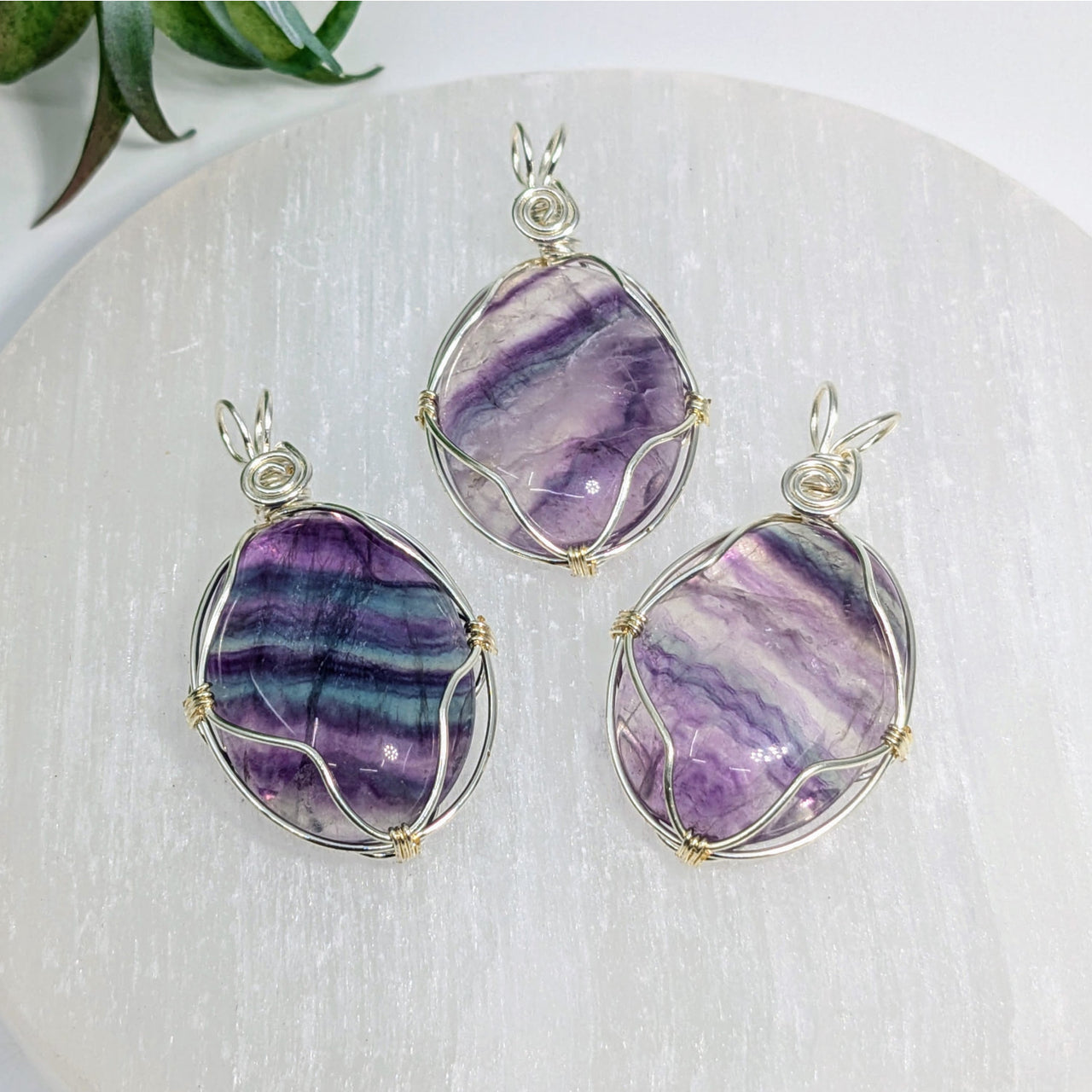 Three wire-wrapped Fluorite pendants displayed in the Fluorite 1.75-inch Wire Wrap Pendant #LV7530