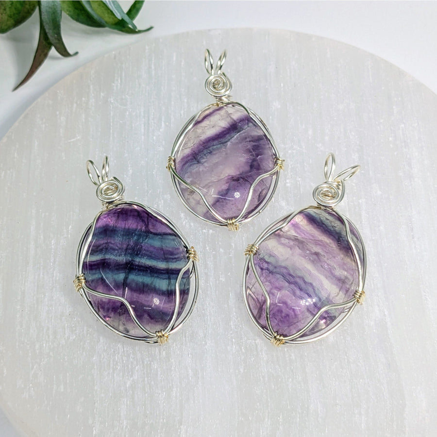 Three wire-wrapped Fluorite pendants displayed in the Fluorite 1.75-inch Wire Wrap Pendant #LV7530