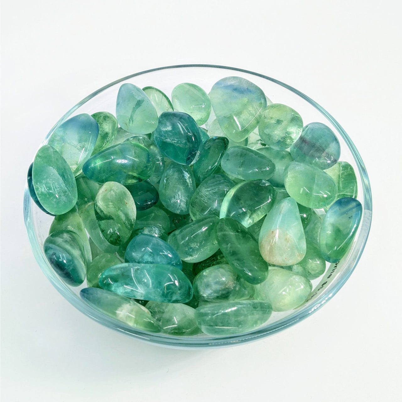 Polished green fluorite crystals in a glass bowl for Fluorite Assorted Tumbled